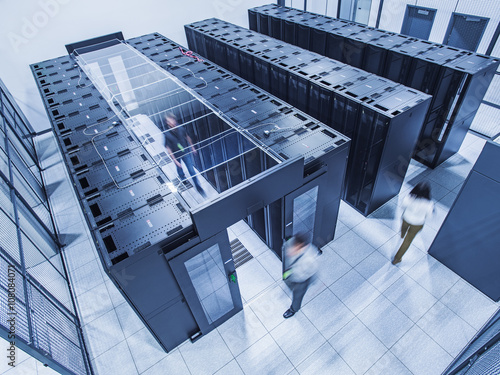 High angle view of technicians walking in server room photo