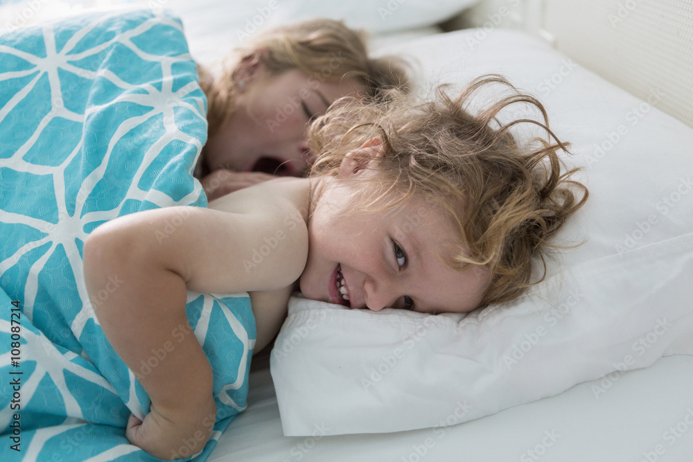 Caucasian brother and sister laying in bed Caucasian brother and sister laying in bed