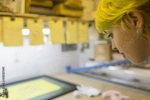 Caucasian artist working in screen print workshop photo