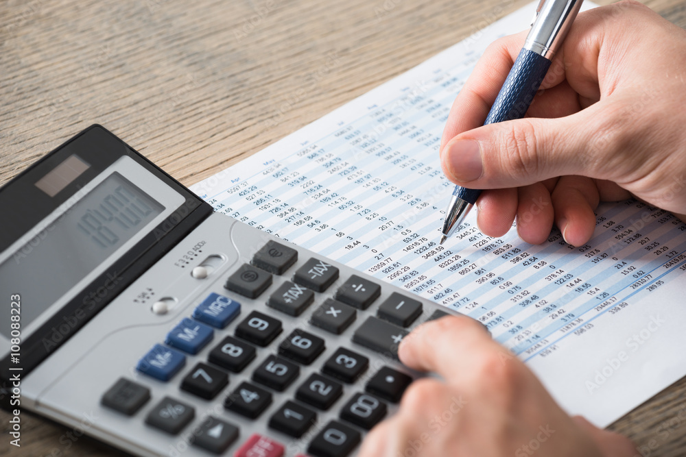 Businessman Analyzing Accounting Document With Calculator Businessman Analyzing Accounting Document With Calculator
