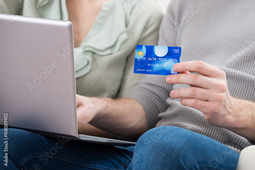 Couple Holding Laptop And Credit Card