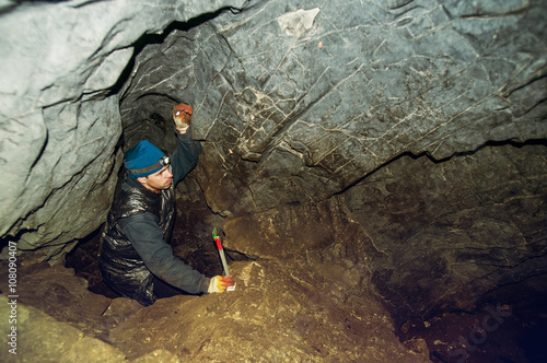 Caucasian climber exploring rock cave photo