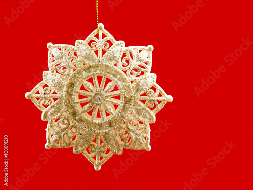 view of golden christmas bauble against red background.