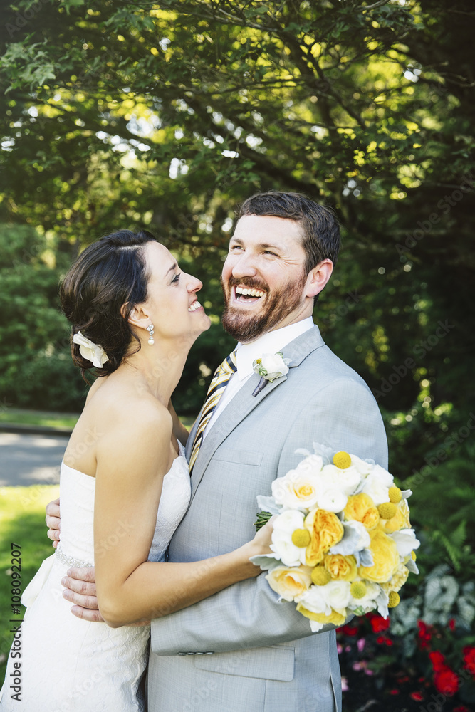 Caucasian bride and groom hugging in garden Caucasian bride and groom hugging in garden