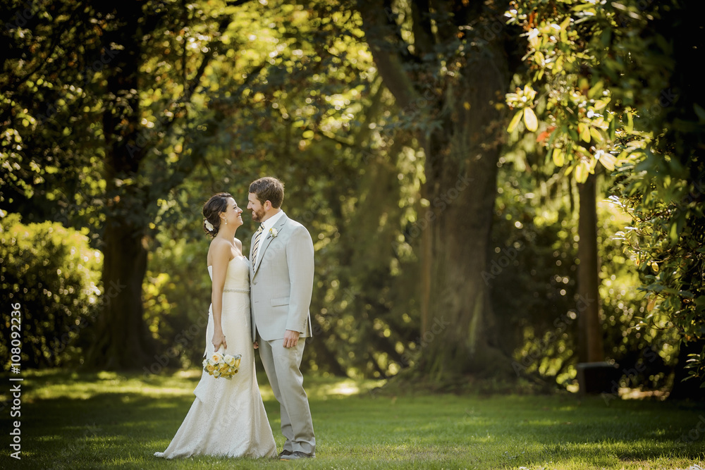 Caucasian bride and groom walking in grass Caucasian bride and groom walking in grass