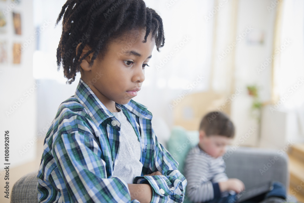 Boy ignoring friend in living room Boy ignoring friend in living room