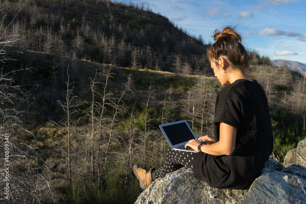 Woman with laptop on the mountain