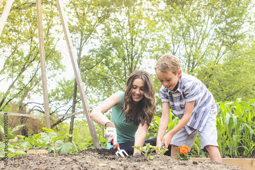 Mother and son planting in garden photo