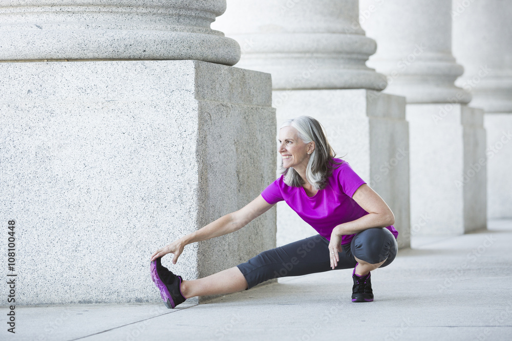 Caucasian woman stretching outside courthouse Caucasian woman stretching outside courthouse