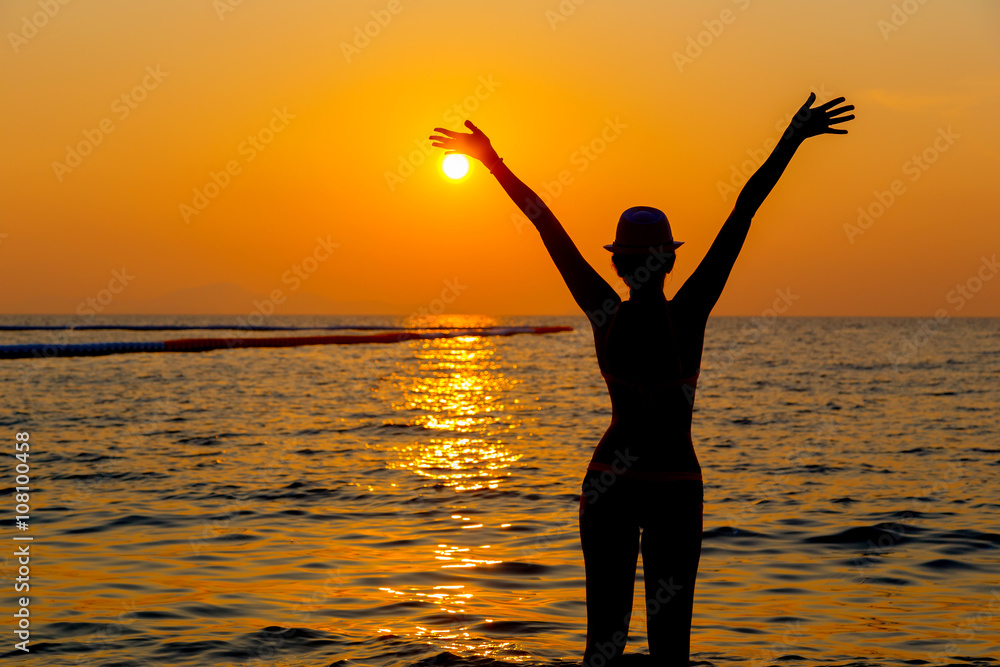 Fototapeta premium Portrait of young woman as silhouette by the sea