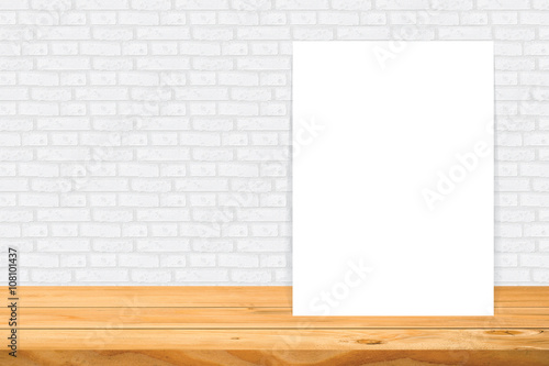 Blank frame on wooden table at white tile wall,Template mock up for adding your design and leave space beside frame for adding more text.