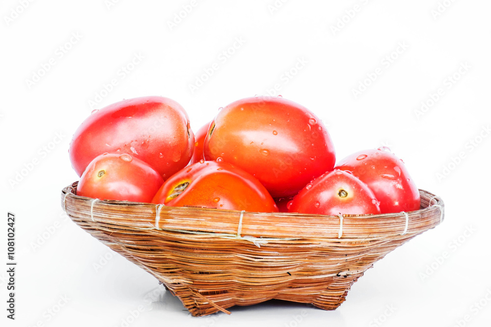 Fresh plum tomato in wooden rattan basket on white background Fresh plum tomato in wooden rattan basket on white background