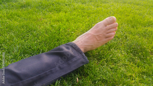 Barefoot on green grass under the sunlight
