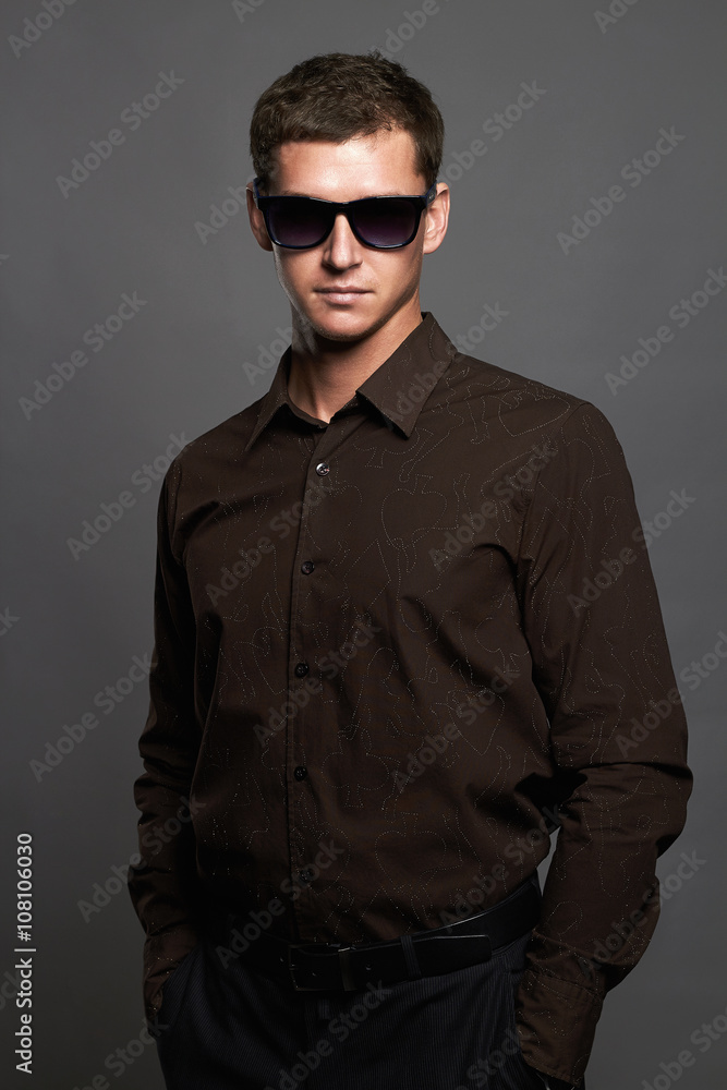 fashion portrait of handsome man in sunglasses.Brutal guy fashion portrait of handsome man in sunglasses.Brutal guy