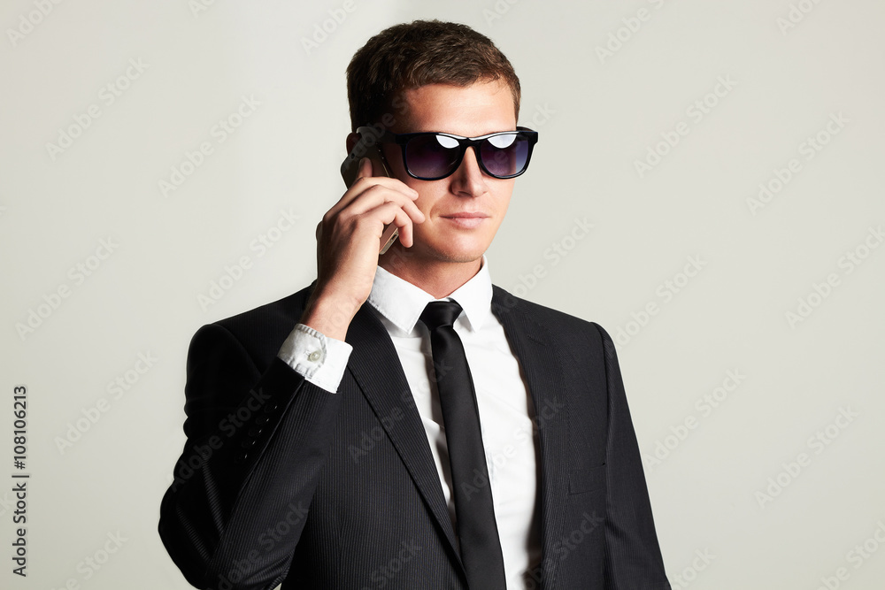 young businessman on the phone.handsome man in suit and sunglasses young businessman on the phone.handsome man in suit and sunglasses