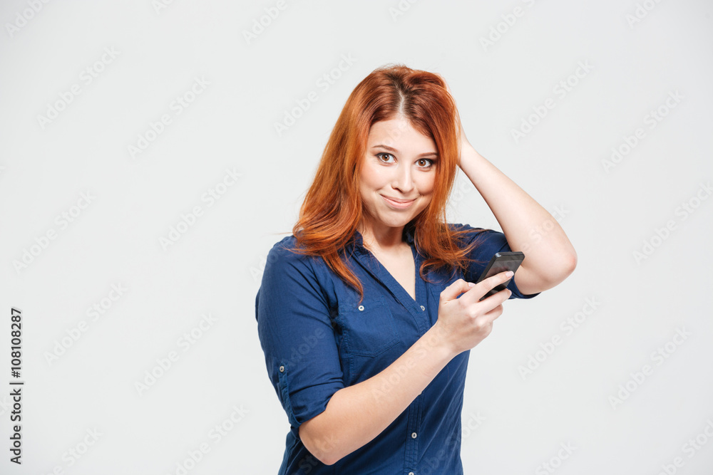 Smiling pretty redhead young woman using smartphone Smiling pretty redhead young woman using smartphone