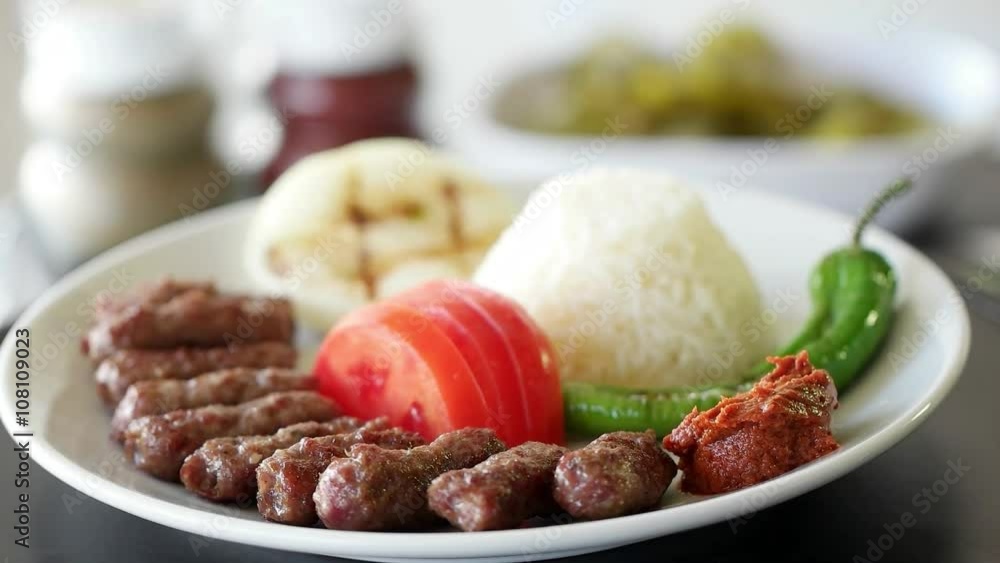 Turkish meatball inegol kofte with rice, onion, tomatoes and green pepper. Rotating shot. Slow motion and close up. Turkish meatball inegol kofte with rice, onion, tomatoes and green pepper. Rotating shot. Slow motion and close up.