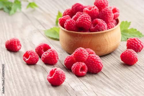 Raspberries in bowl on wooden table. Close up, high resolution product. Harvest Concept