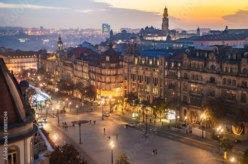 Aerial view of Aliados / Liberdade Square and Clerigos Tower on the background in old town of Porto. Sunset view with Christmas tree, street ligts and soft clouds.