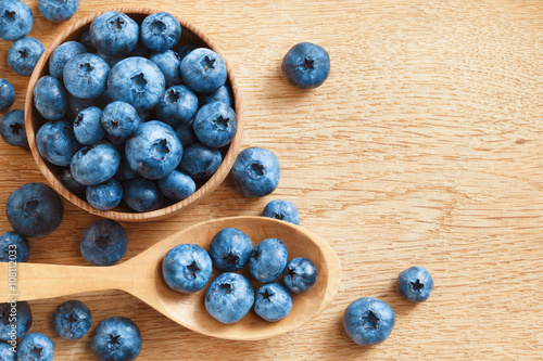 Organic blueberries in bowl on wooden background. Close up, top view, high resolution product. Harvest Concept