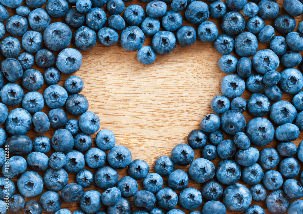 Heart shape made of premium Blueberries on wooden background. Close up, top view, high resolution product. Harvest Concept Heart shape made of premium Blueberries on wooden background. Close up, top view, high resolution product. Harvest Concept