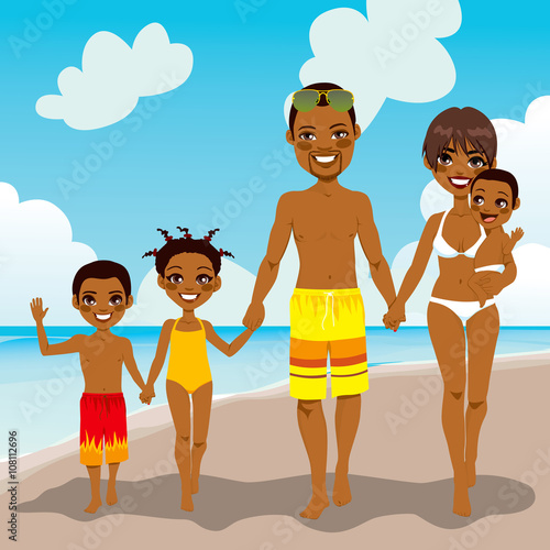 Happy African American family enjoying beach vacation walking on shore sand