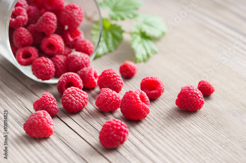 Fresh raspberries in bowl on wooden table. Close up, high resolution product. Harvest Concept
