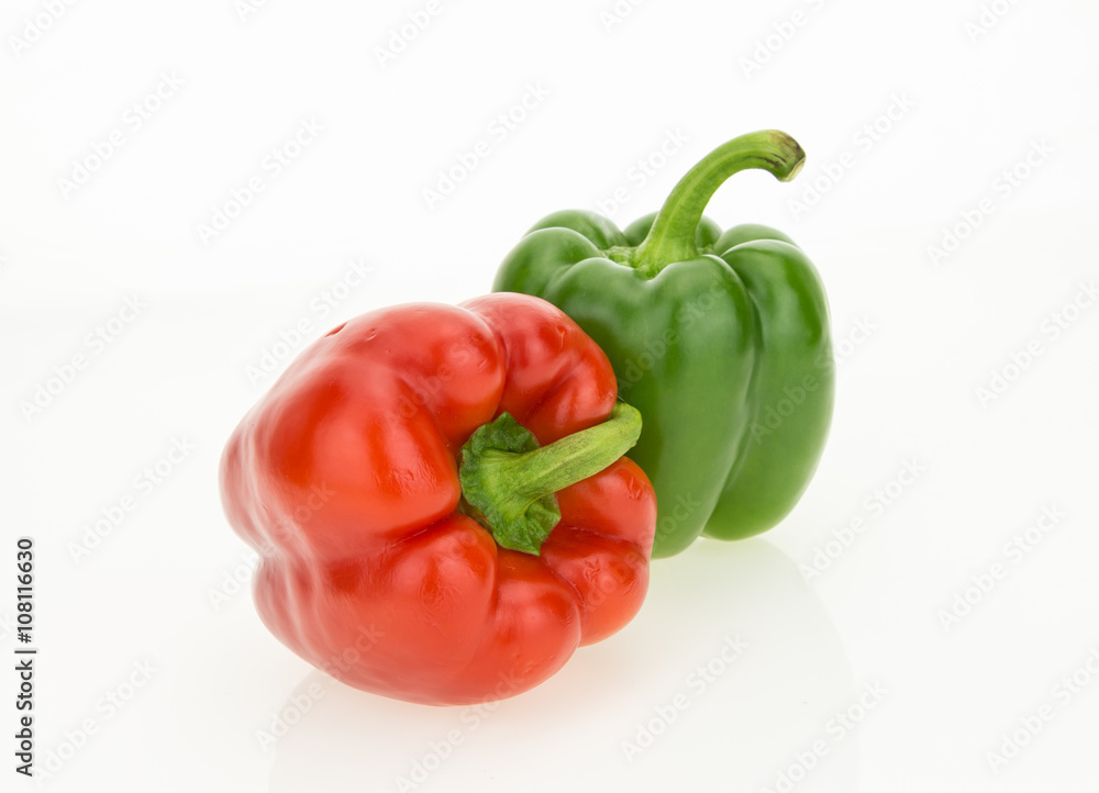 Fresh red and green bell peppers, isolated on white background.