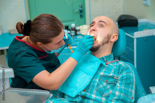 Photo dentist treating teeth to the patient