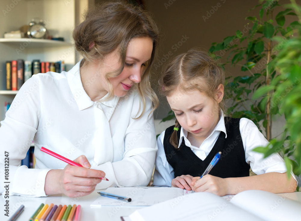 Mother helping daughter with homework at home. Mother helping daughter with homework at home.