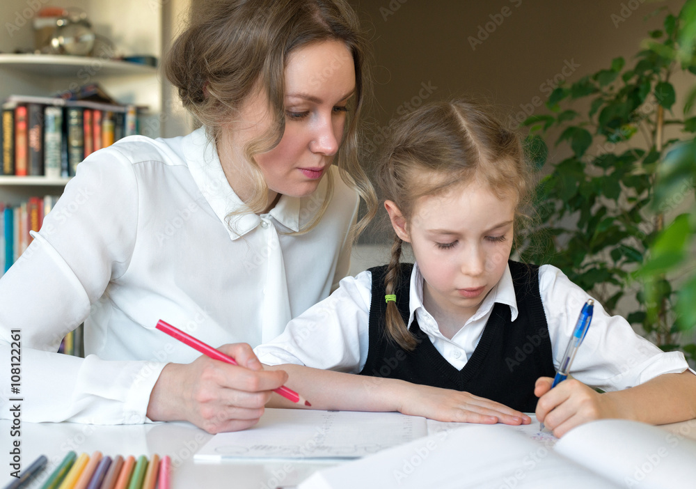 Mother helping daughter with homework at home. Mother helping daughter with homework at home.