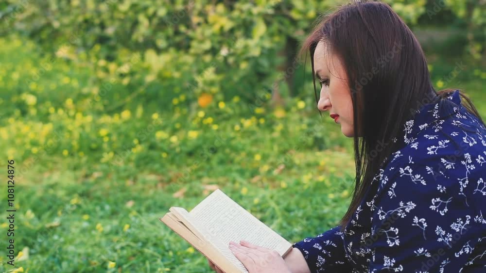 Attractive woman reading book in park. Attractive woman reading book in park.