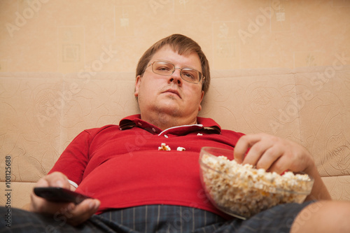 фотографія fat man eating popcorn