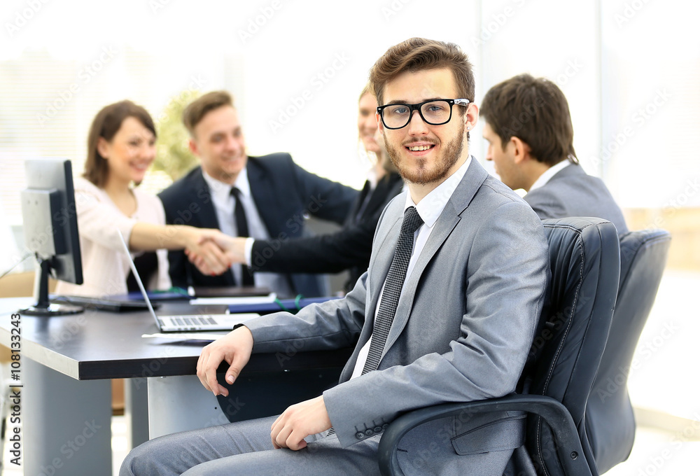 Portrait of mature business man smiling during meeting with colleagues in background Portrait of mature business man smiling during meeting with colleagues in background