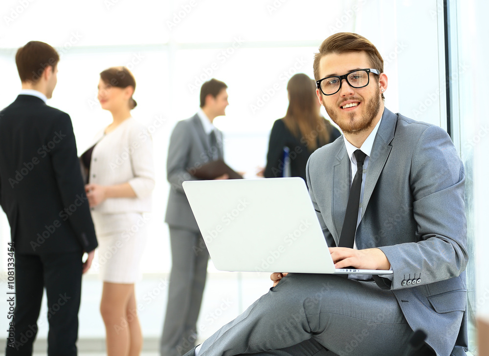 Portrait of a handsome young business man with people in background at office meeting Portrait of a handsome young business man with people in background at office meeting