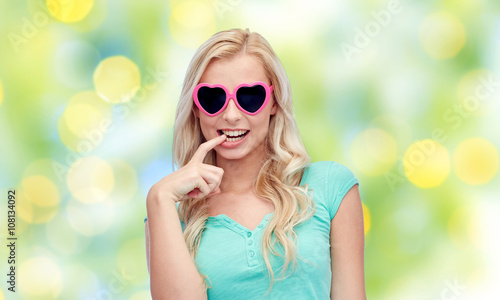 happy young woman in heart shape sunglasses