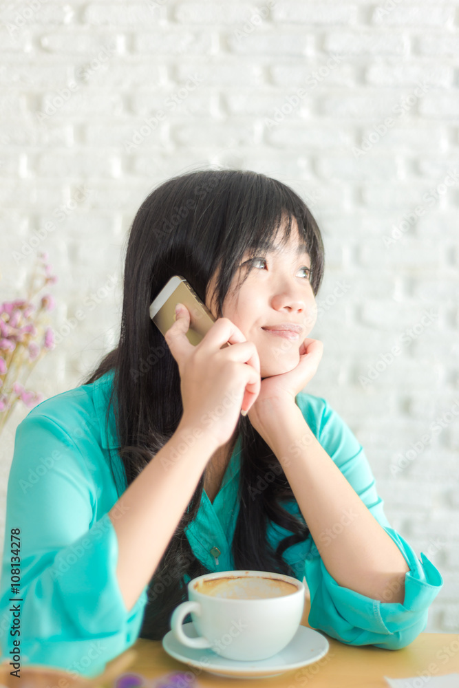 Woman holding cellphone with a cup of coffee in cafe, Art late coffee shop Woman holding cellphone with a cup of coffee in cafe, Art late coffee shop