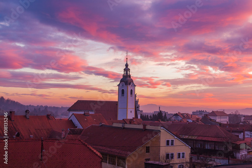 Kamnik, Slovenia - January 25, 2016. Tower of The Immaculate Conception Church above the roofs of the town at sunset. © donaldyan1