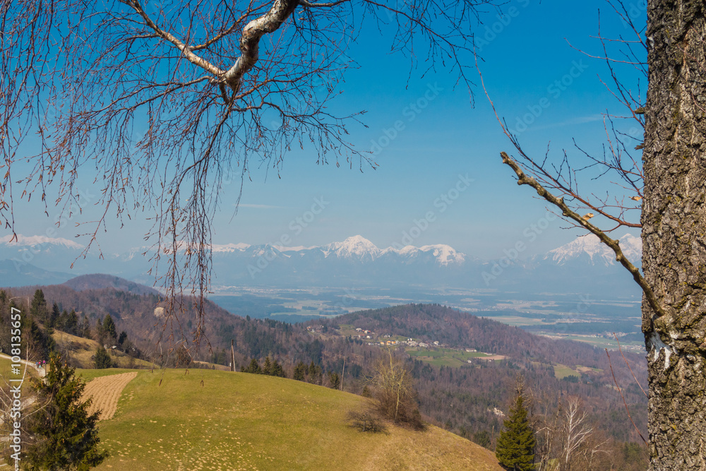 Snowy alpine peaks and valley spring view from the hill. Snowy alpine peaks and valley spring view from the hill.