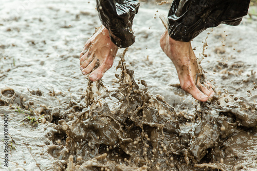 Obraz na plátne Feet splashing in muddy water