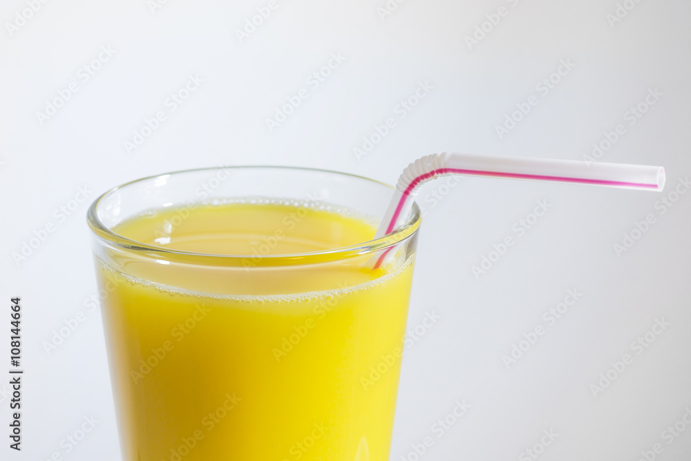 glass of orange juice with a straw glass of orange juice with a straw