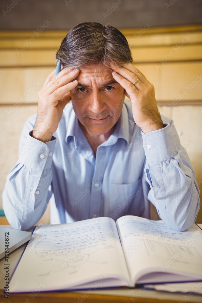 Naklejka premium Portrait of depressed professor sitting with notes