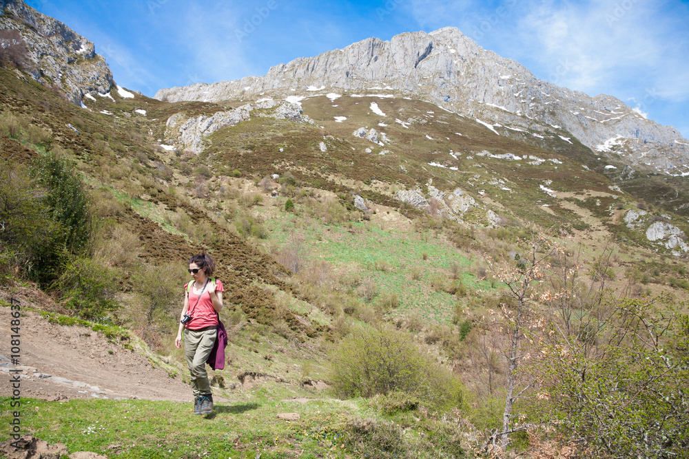 woman trekking down rocky peak