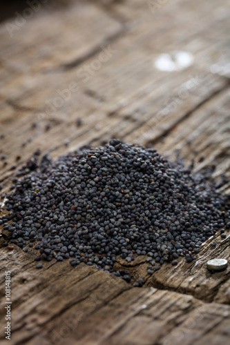 Dried poppy seeds set on old wooden surface