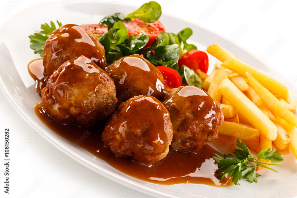 Roasted meatballs, chips and vegetables 