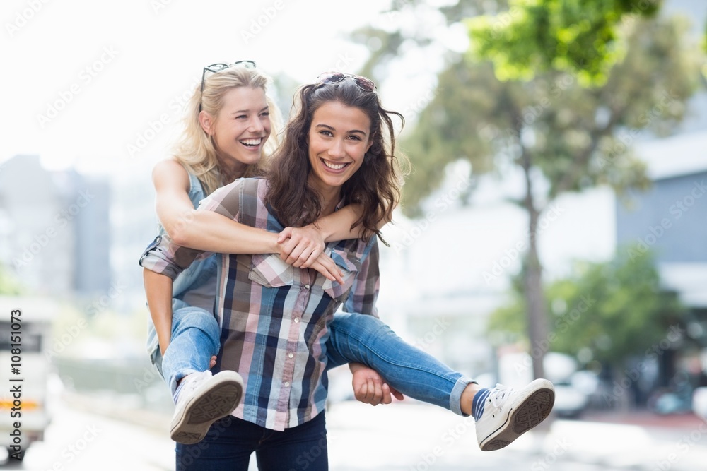 Woman giving piggyback to her friend