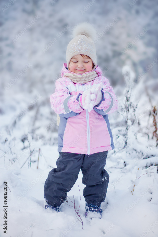 Cute little girl in the winter forest