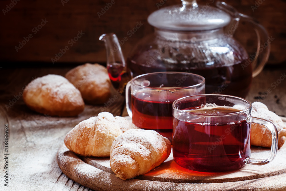 Ceylon black tea in glass cups with kettle, fresh croissants, vi Ceylon black tea in glass cups with kettle, fresh croissants, vi