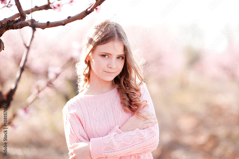 Beautiful blonde teenage girl 14-16 year old posing in peach garden. Looking at camera. Elegance. Beautiful blonde teenage girl 14-16 year old posing in peach garden. Looking at camera. Elegance.