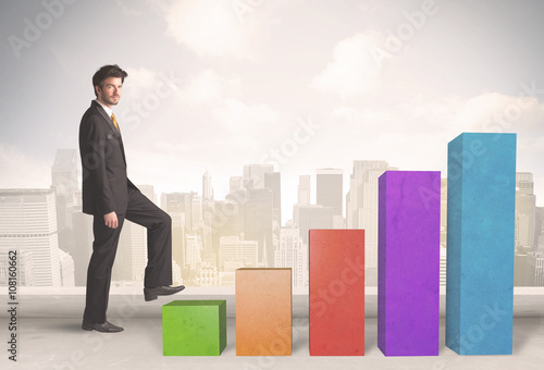 Business person climbing up on colourful chart pillars concept